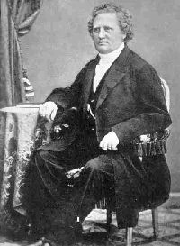 C. O. Rosenius. Vanha mustavalkoinen muotokuva miehestä, jolla on puku, istuu tuolilla.